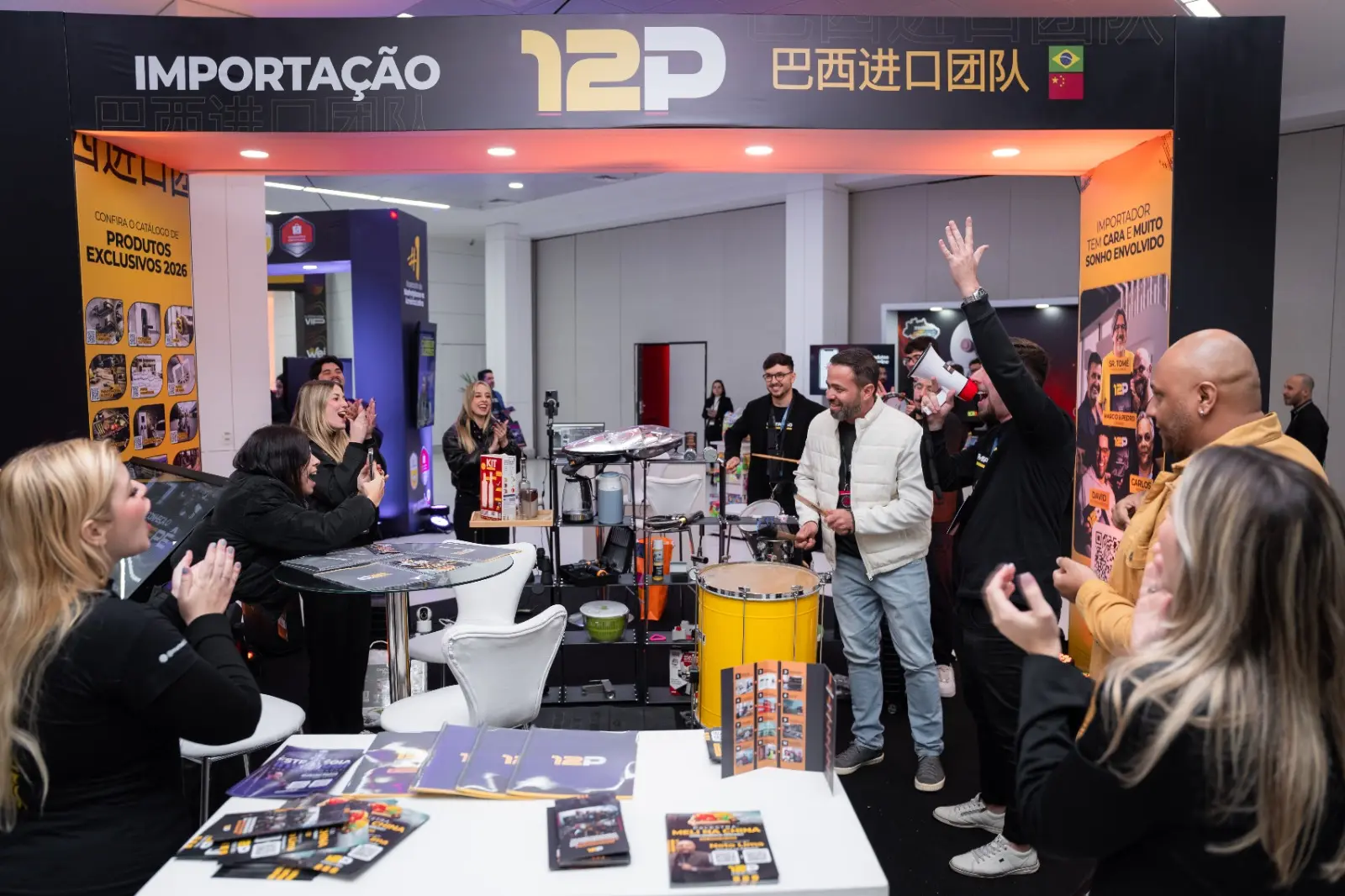 Equipe comemorando em frente ao estande da 12P